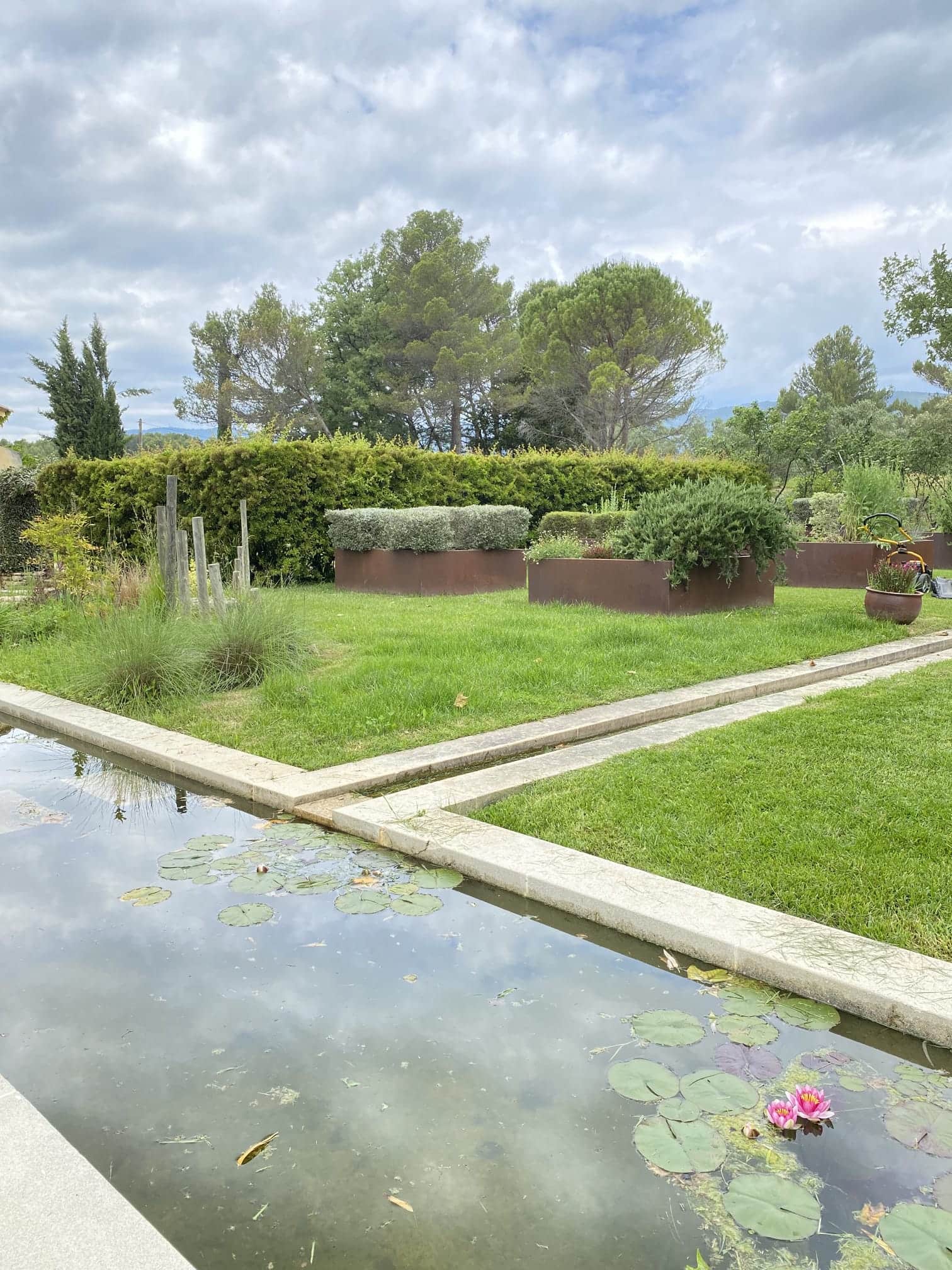 Création d'un bassin avec nénuphars, pelouse et jardinières en acier corten, conception paysagère Jardin Aixeption à Aix-en-Provence