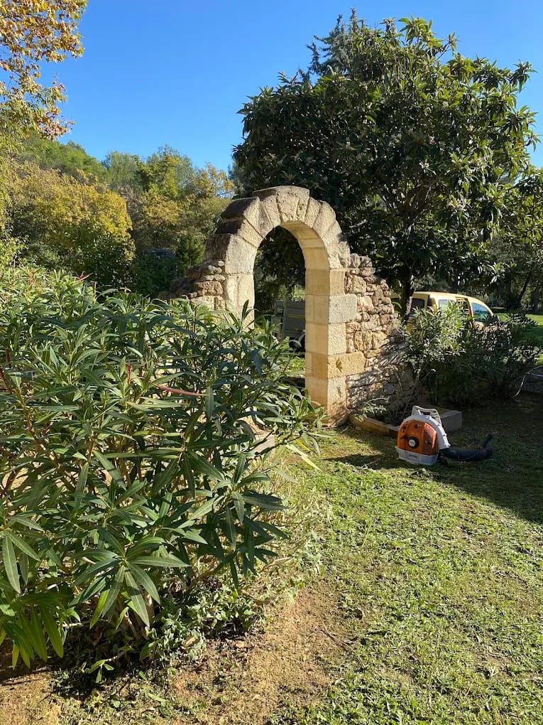 Entretien de massifs avec oliviers et nettoyage au souffleur, aménagement autour d'une ruine/arc en pierre ancienne à Aix-en-Provence