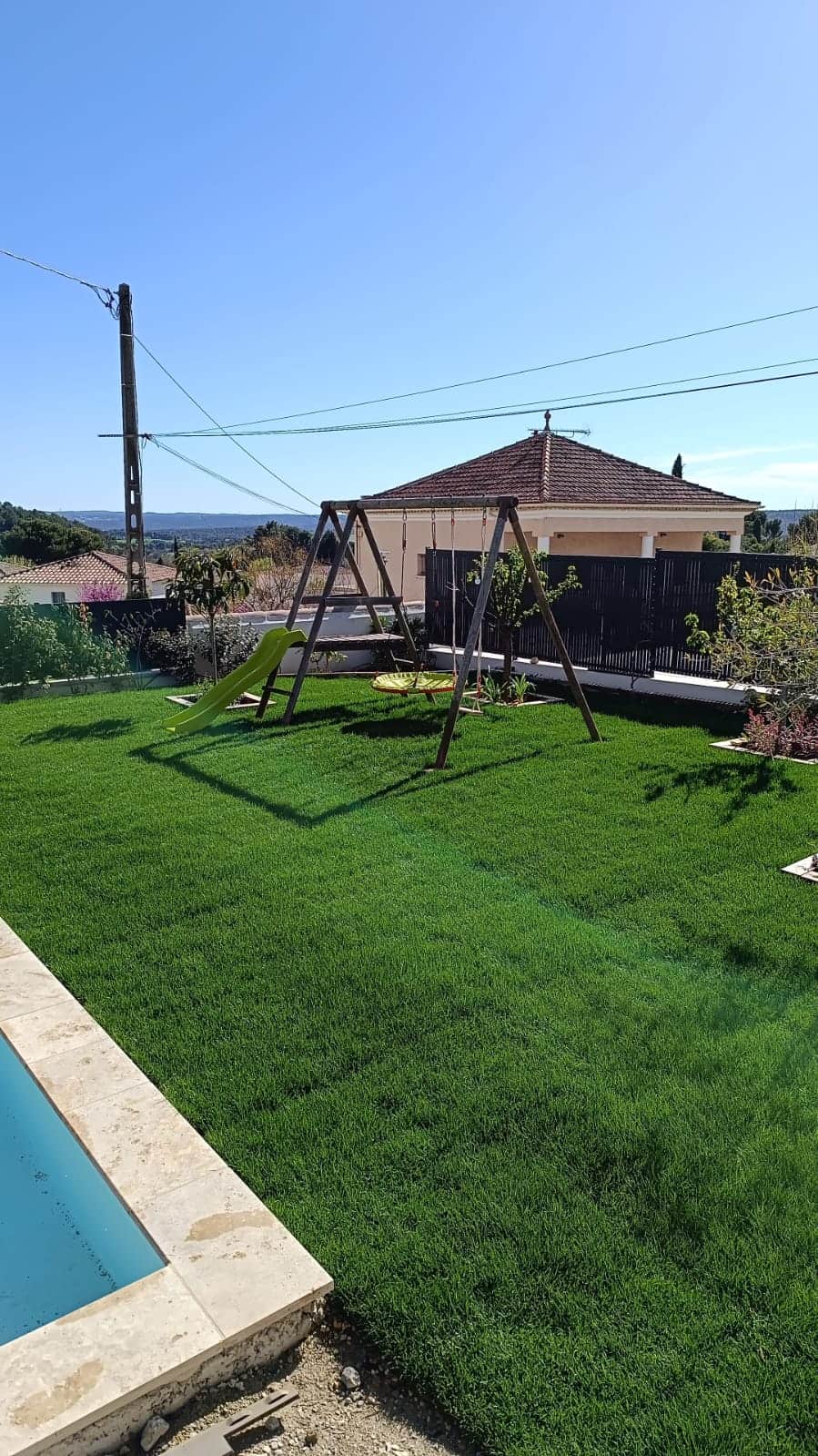 Création d'un espace vert familial avec pelouse, piscine et aire de jeux pour enfants par Jardin Aixeption à Aix-en-Provence